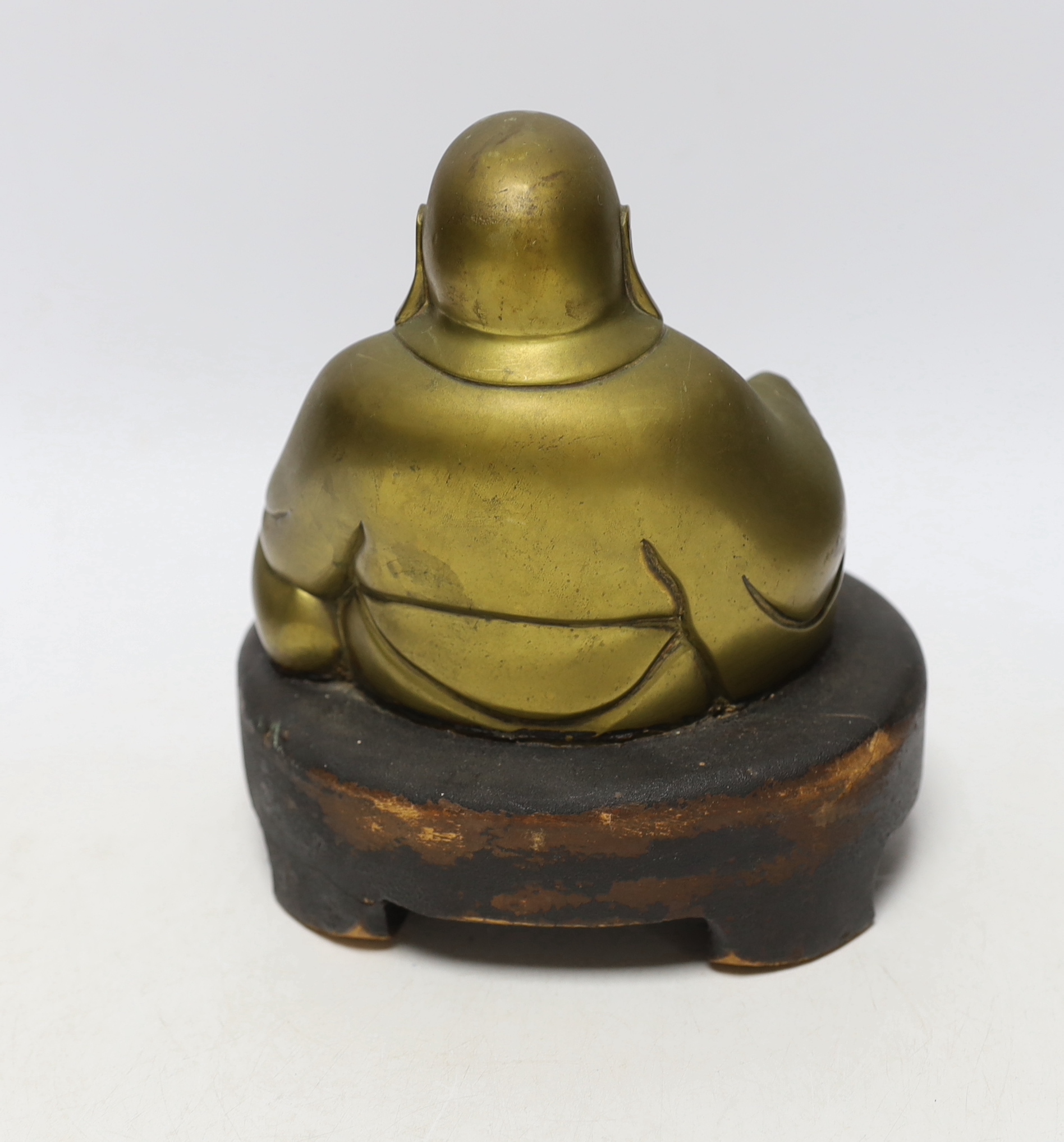 A bronze model of a seated Budai on hardwood base, 20cm